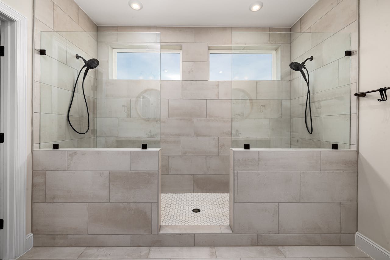A sleek, contemporary dual shower bathroom featuring elegant tile work and modern fixtures.